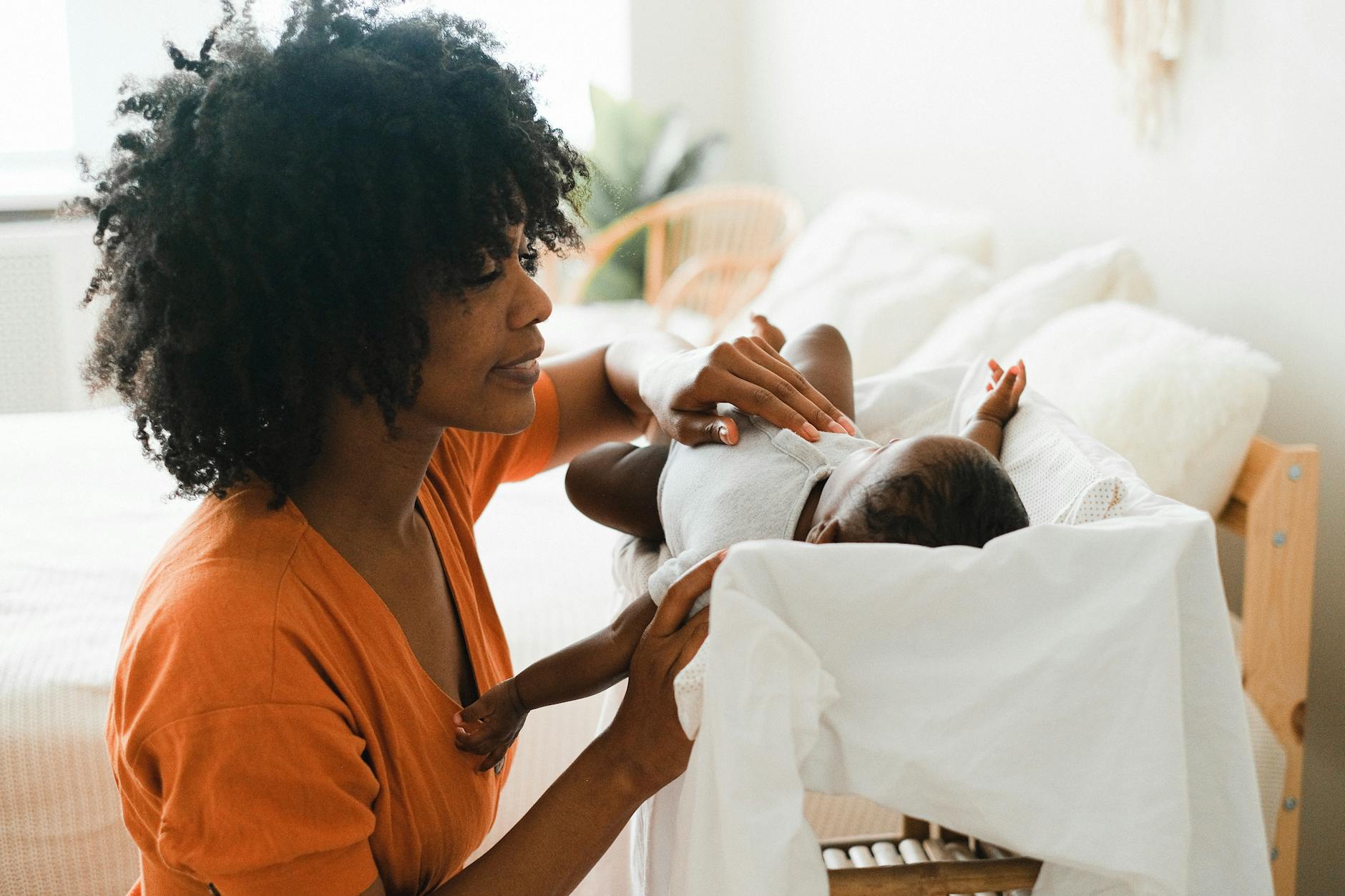 a woman in orange shirt looking at her baby